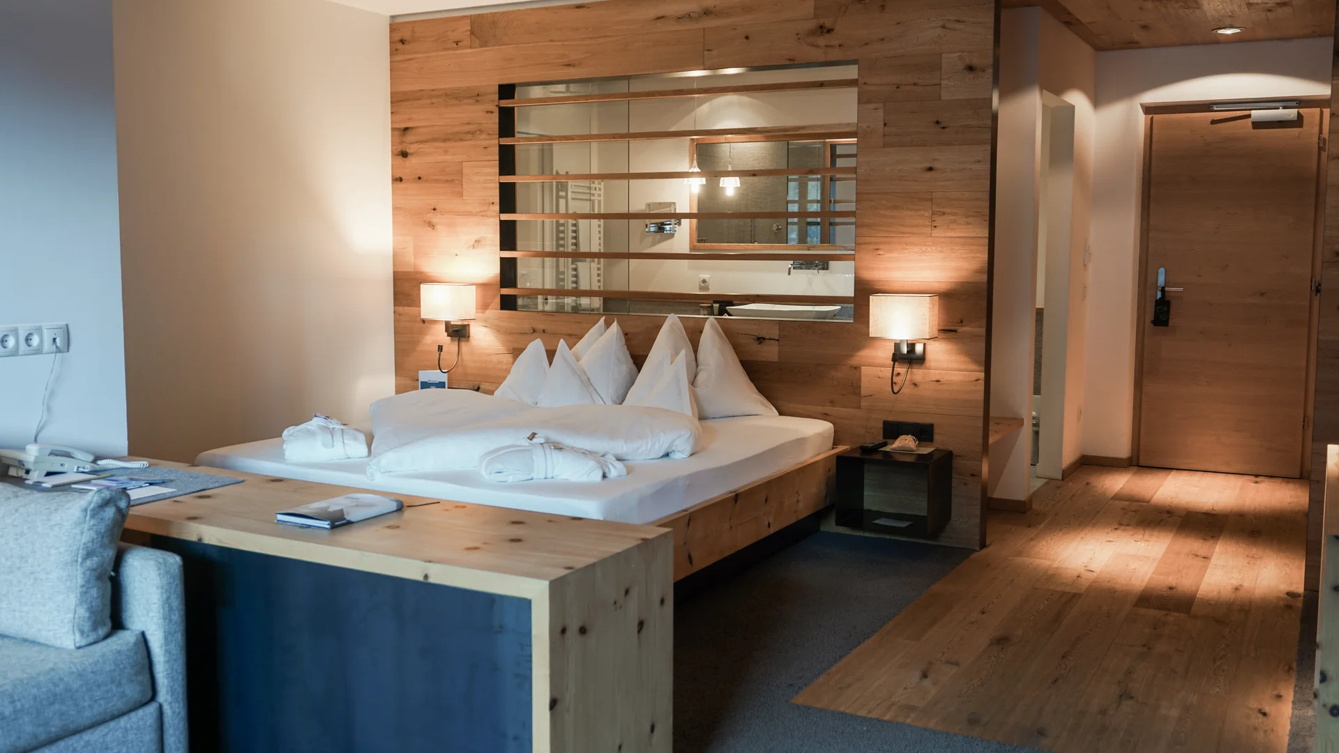 Modernes Hotelzimmer mit Holzakzenten, Doppelbett und weichen Decken