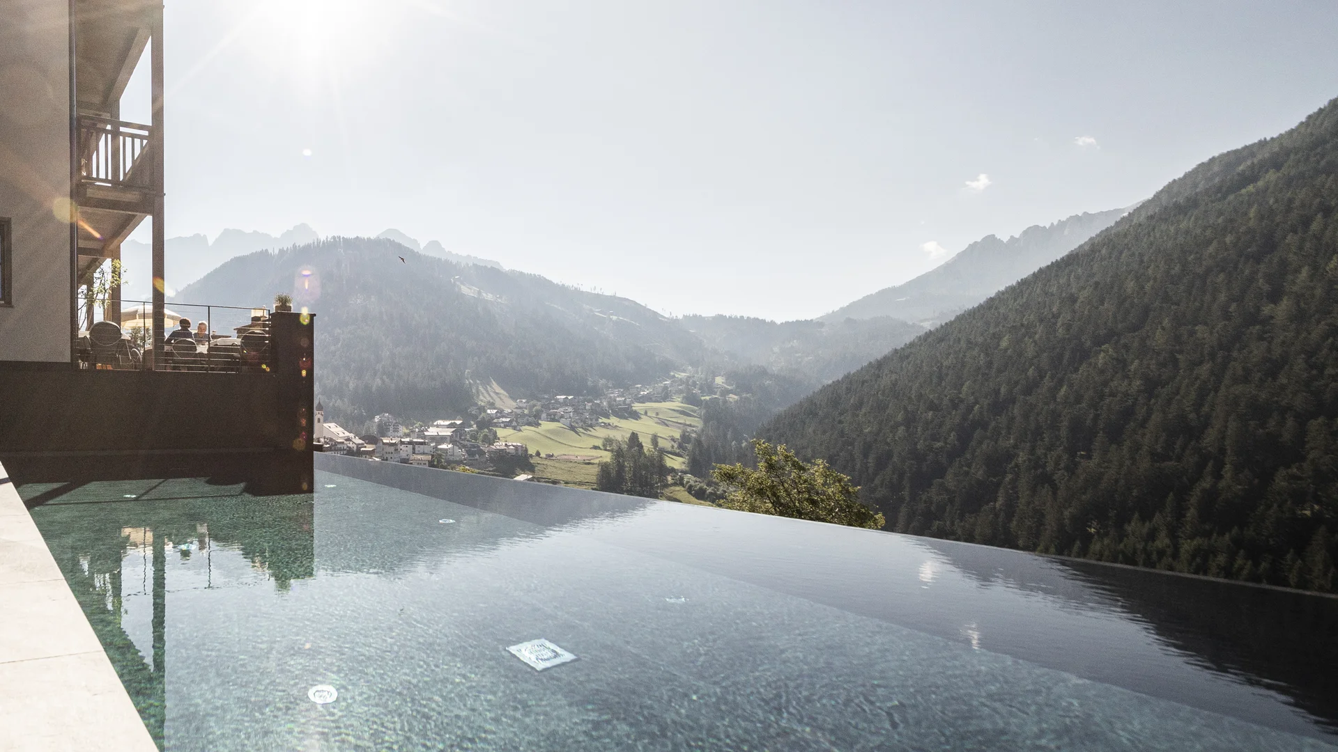 Infinity-Pool mit Bergblick und Sonnenschein an einem klaren Tag