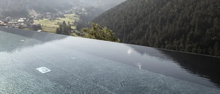 Infinity-Pool mit Bergblick und Sonnenschein an einem klaren Tag