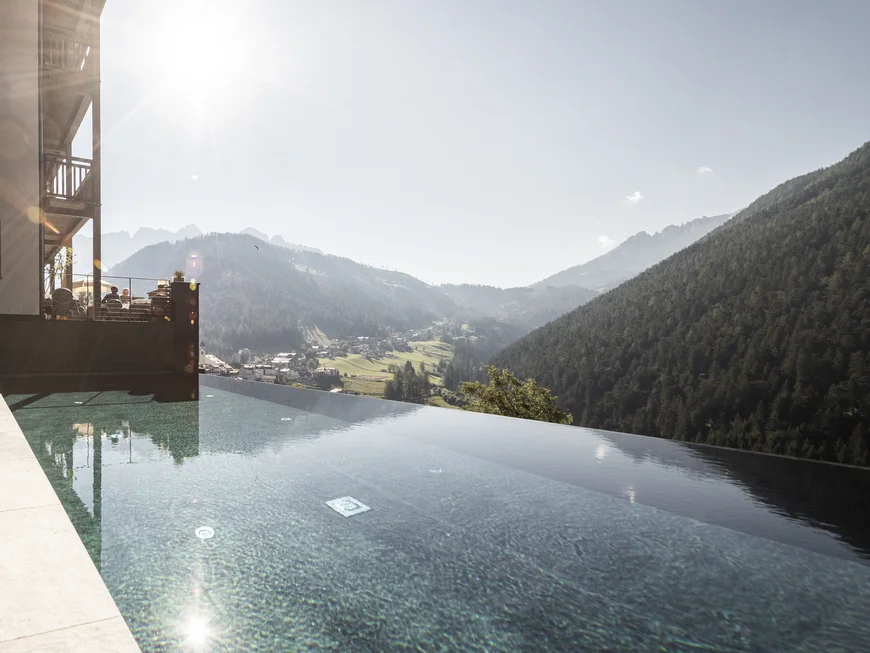 Das ist nicht irgendein nachhaltiges Hotel in Südtirol Infinity-Pool mit Bergblick und Sonnenschein an einem klaren Tag