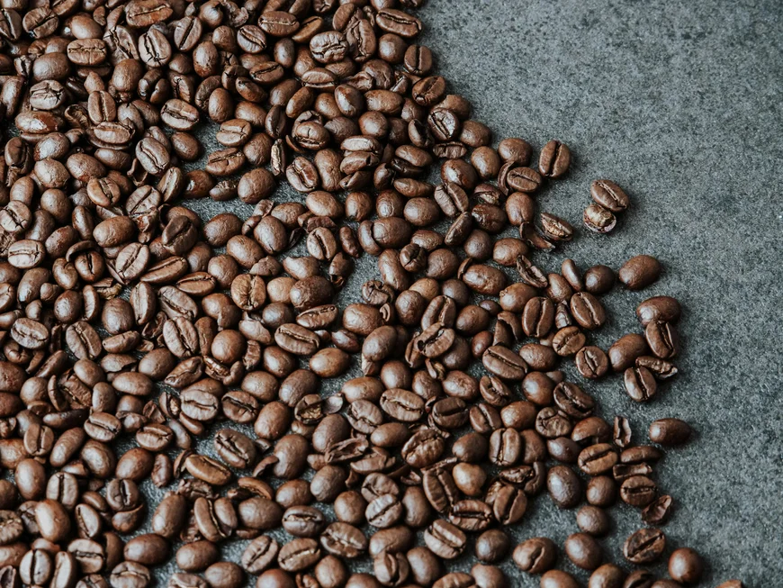 Empfohlen: das Boutiquehotel Friedrich Nahaufnahme von gerösteten Kaffeebohnen auf dunklem Untergrund