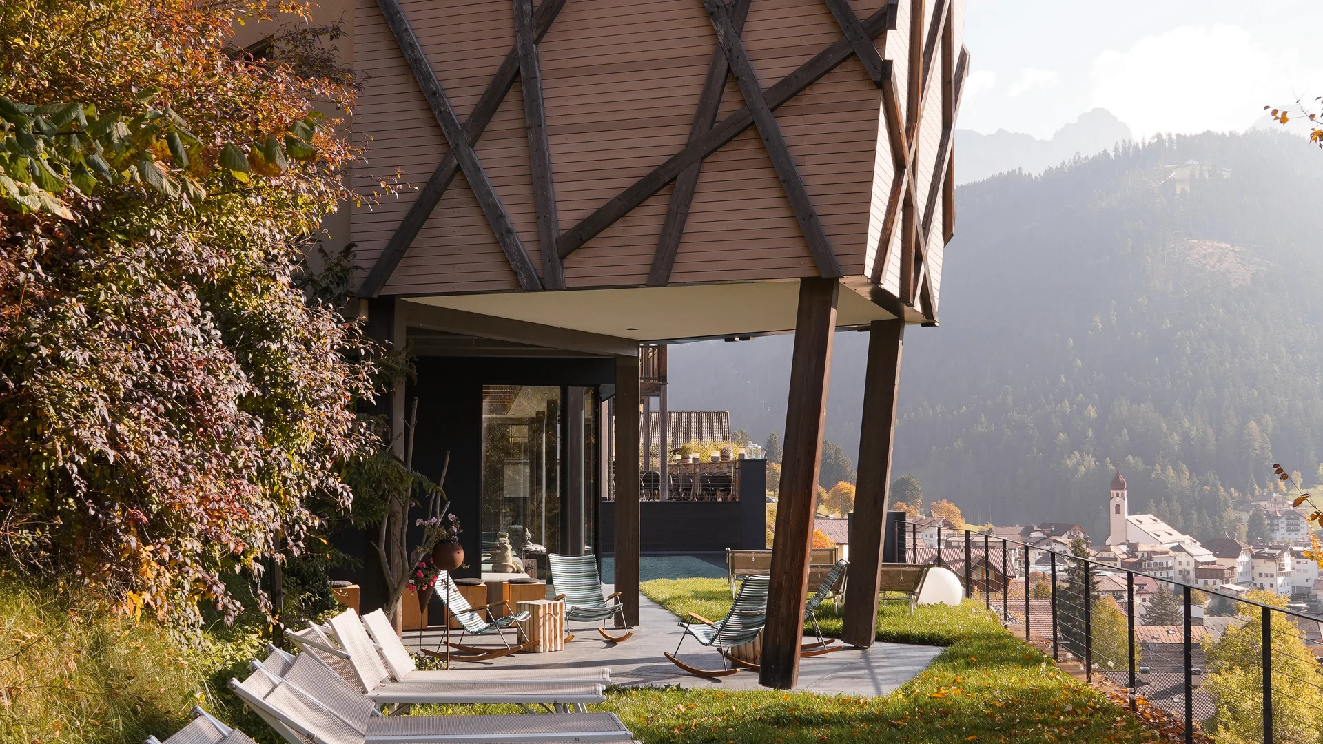 Moderne Architektur mit Liegestühlen auf Rasen und Bergblick im Hintergrund