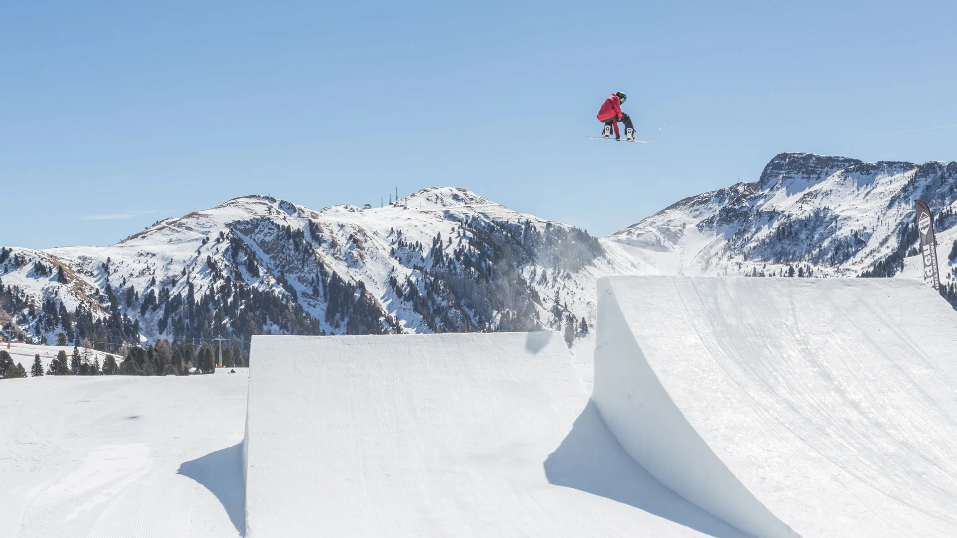 Il Friedrich in foto Snowboarder salta sopra una rampa innevata nelle Alpi