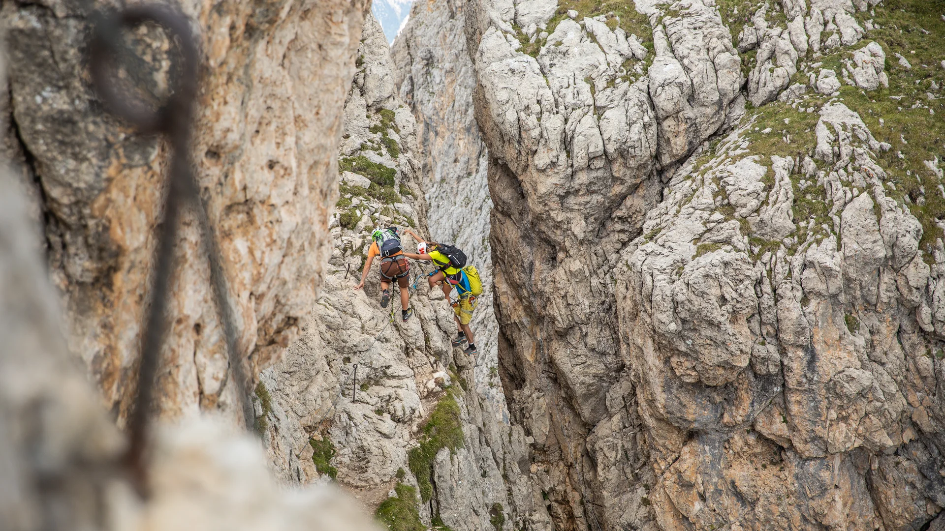 Zwei Kletterer erklimmen eine felsige Bergschlucht mit Kletterausrüstung