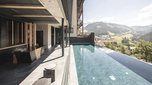 Accessibility Infinity pool with mountain view at modern hotel in sunny landscape