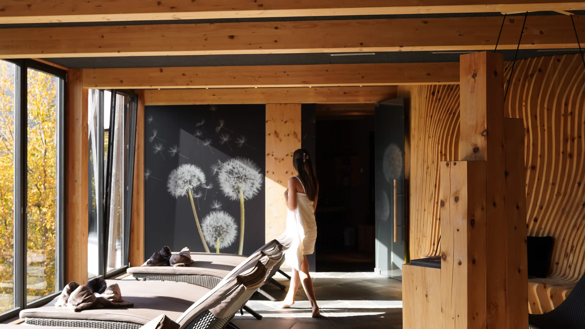 Ruheraum mit Liegen und Frau in weißem Handtuch in einem Holz-Interieur