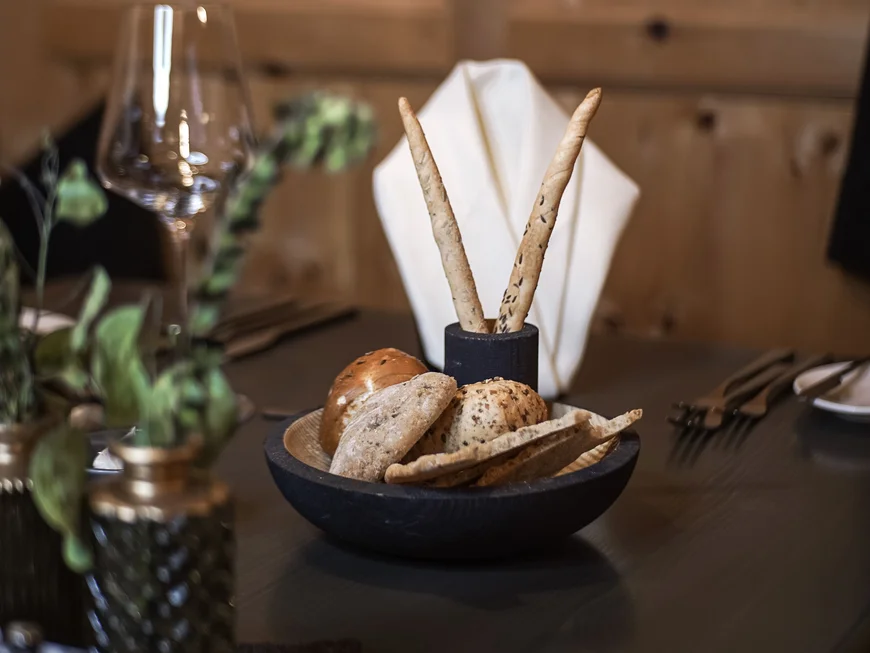 Empfohlen: das Boutiquehotel Friedrich Verschiedene Brotsorten und Grissini auf einem gedeckten Restauranttisch