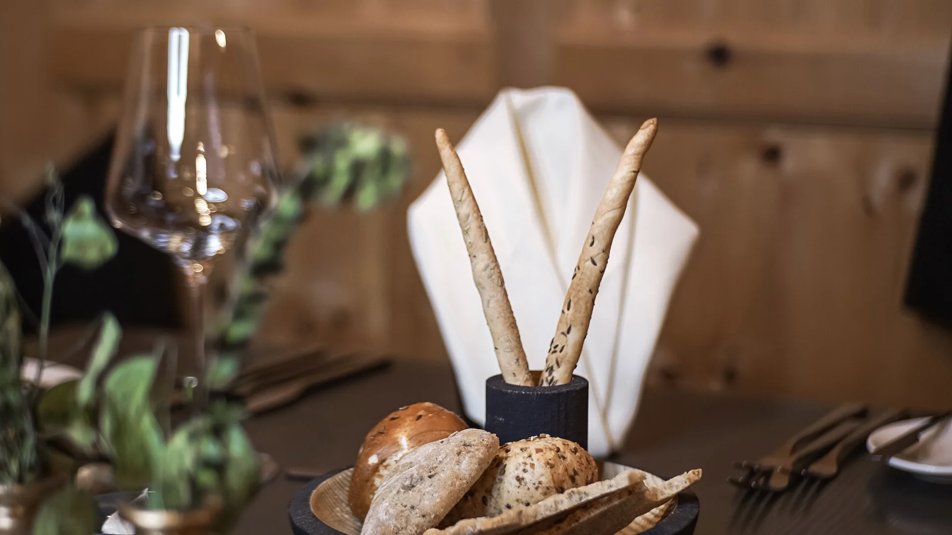 Verschiedene Brotsorten und Grissini auf einem gedeckten Restauranttisch