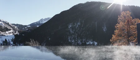 Dampfendes beheiztes Pool mit Bergblick im Sonnenschein