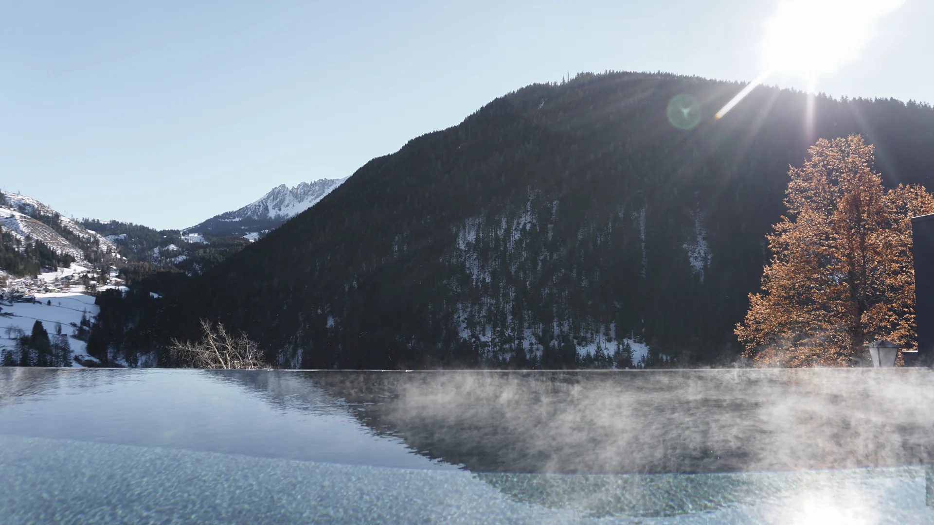 Friedrich ist DAS Boutiquehotel in den Dolomiten Dampfendes beheiztes Pool mit Bergblick im Sonnenschein