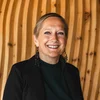 Friedrich ist DAS Boutiquehotel in den Dolomiten Lächelnde Frau vor geschwungenen Holzwänden