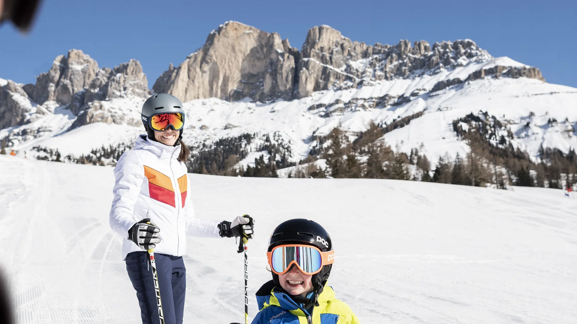 Il Friedrich in foto Bambino e adulto che sciano davanti a montagne innevate sotto un cielo blu