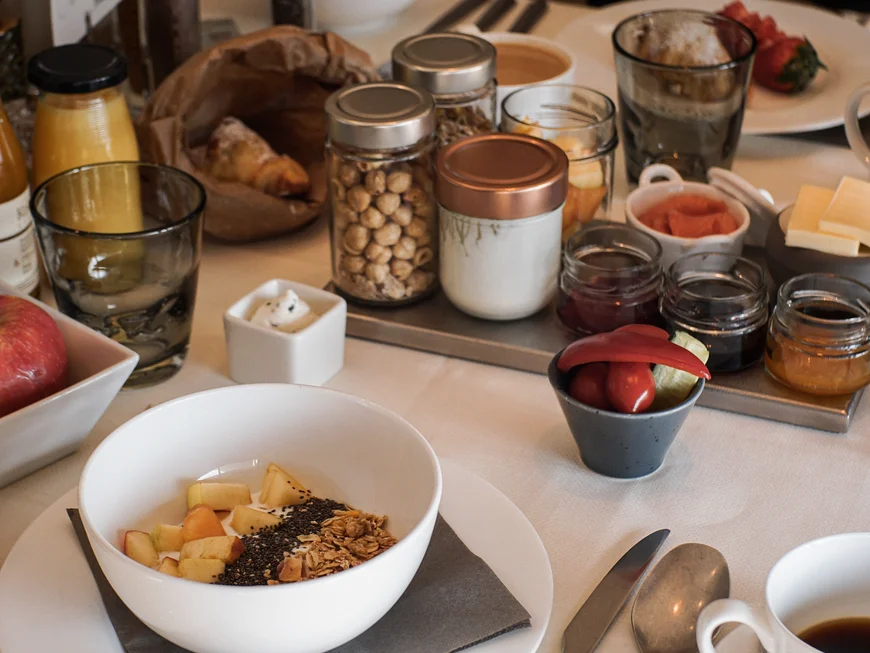 Empfohlen: das Boutiquehotel Friedrich Tisch mit Frühstücksgeschirr und verschiedenen Frühstückszutaten