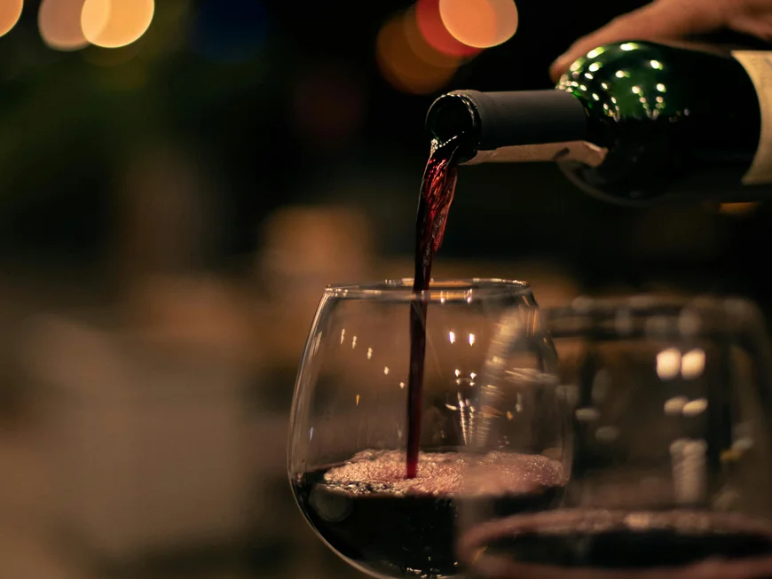 Empfohlen: das Boutiquehotel Friedrich Rotwein wird in ein Glas bei gedimmtem Licht eingeschenkt